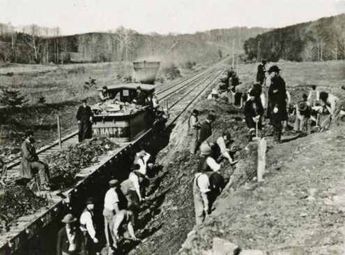 Men dig a hillside as a locomotive waits to haul the dirt - photo from Virginia.